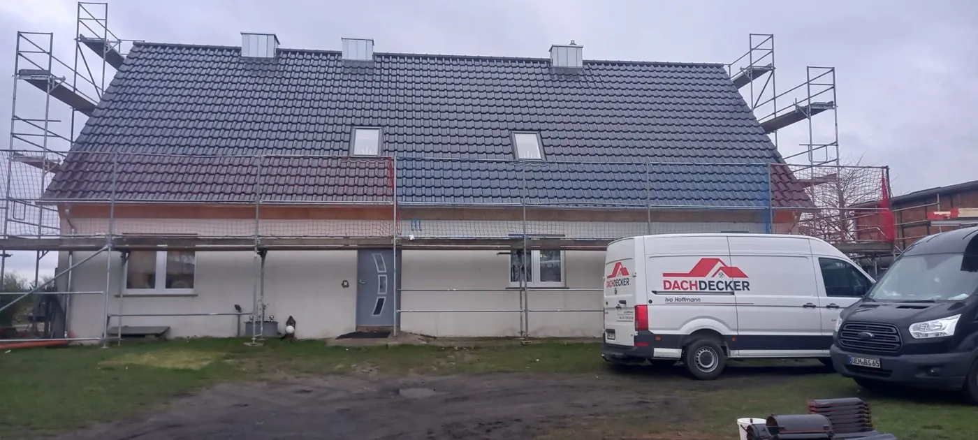 Große Steildach-Neueindeckung mit Tonziegeln, eingerüstetes Haus mit Firmen-Transporter
